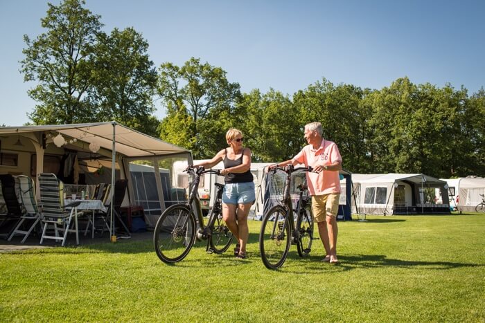 kamperend stel met fietsen aan de hand