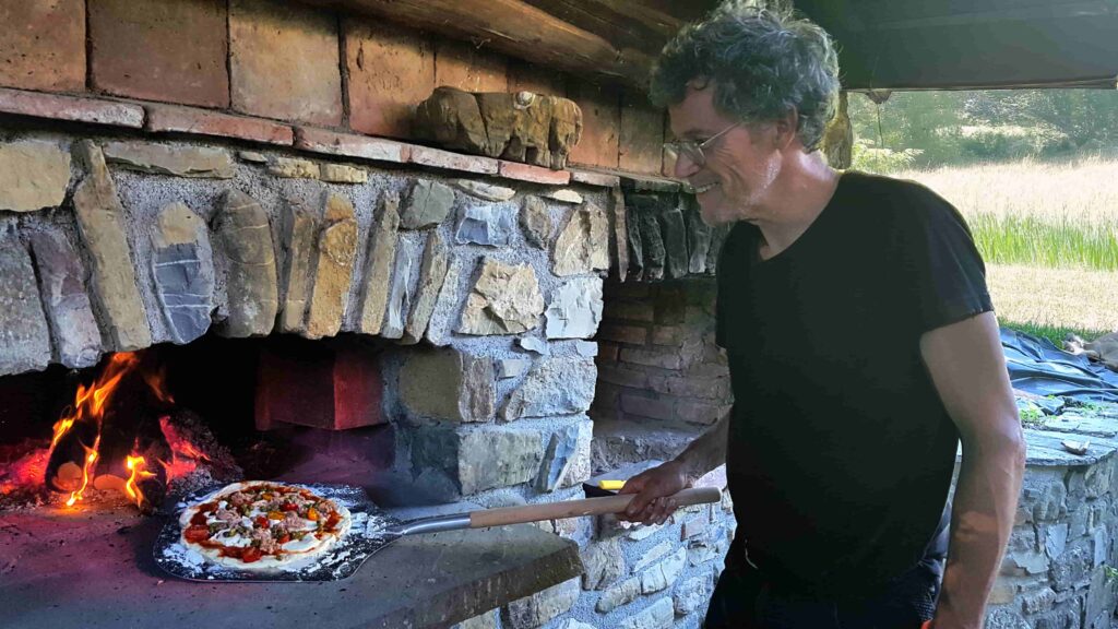 Arnoud Thuss bij de pizzaoven van zijn accommodatie